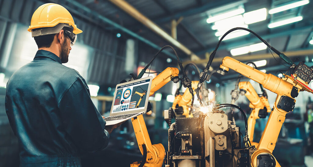 Techniker mit Tablet vor Industrierobotern